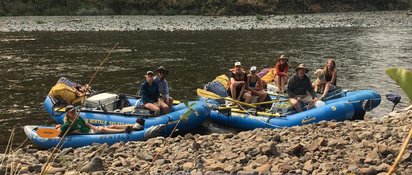 Photo from the 2017 Christmas letter: family members in inflatable rafts pulled up on a rocky river bank