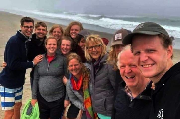 Photo from the 2020 Christmas letter: ten family members crowded together for a selfie on a beach on the Oregon coast